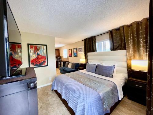 达尼亚滩谢里登公寓式酒店的一间卧室配有一张床和一台平面电视