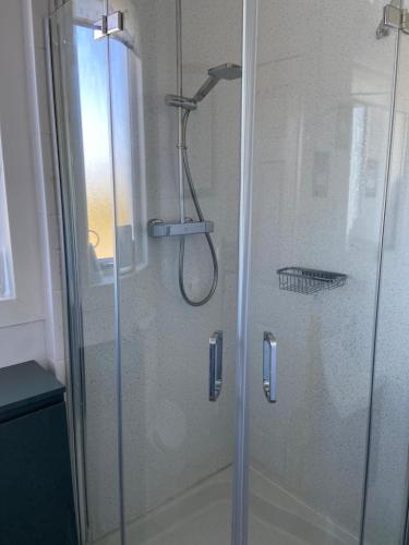 CarlowayTigh-na-Greine的浴室里设有玻璃门淋浴