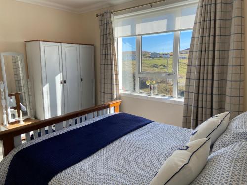CarlowayTigh-na-Greine的一间卧室设有一张床和一个大窗户
