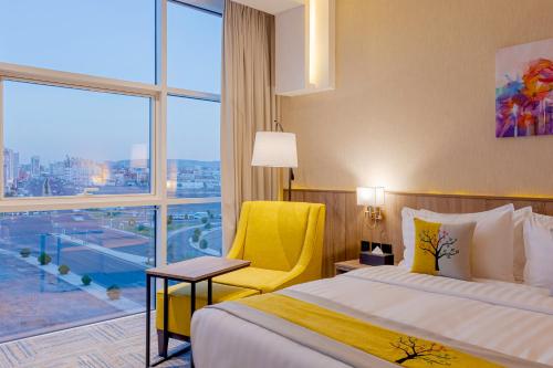 麦地那The Seasons Hotel的酒店的客房 - 带一张床、椅子和窗户