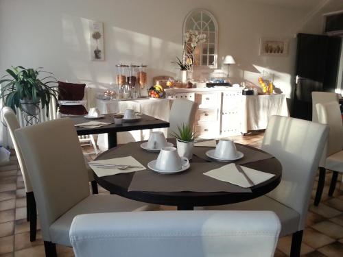 蒙特利马尔美丽阳光酒店的一间带桌子和白色椅子的用餐室