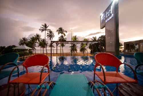 若昂佩索阿内塔那普拉亚酒店的一个带两把椅子和一张桌子的游泳池