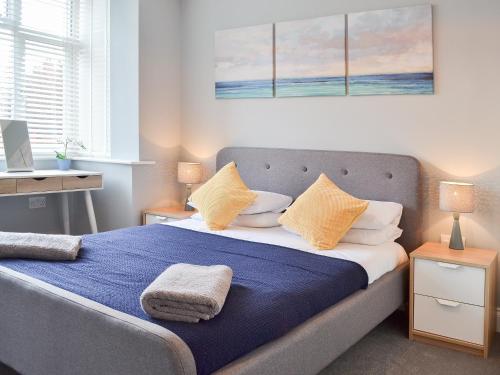 约克Carr Lodge的一间卧室配有一张带蓝色床单和黄色枕头的床。