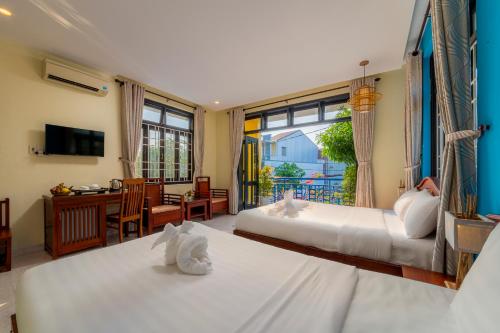 会安Hoi An Heart hostel Villa的一间带两张床的卧室和一间客厅