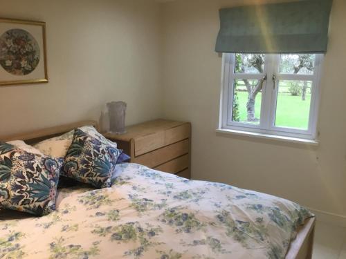 亚特利Cute Cottage 2024 Traveller Award的一间卧室设有一张床和一个窗口