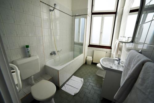 米什科尔茨潘诺尼亚酒店的带浴缸、卫生间和盥洗盆的浴室