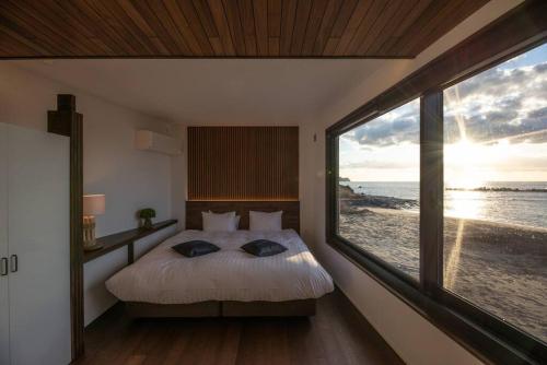 伊豆BLUE ARK的一间卧室设有一张床,享有海景