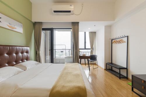 广州广州丽途国际公寓酒店（神舟路地铁站店）的一间卧室配有一张床、一张书桌和一个窗户。