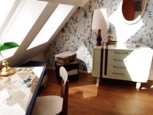 Saint-Julien-de-la-LiègueLe Clos du Buisson的客房设有书桌和带台灯的桌子。