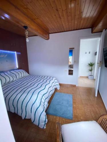 布埃乌Bueu的一间卧室设有两张床和木制天花板