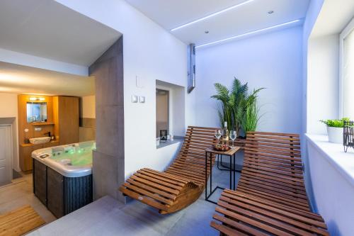 大洛西尼Wellness Apartmány Vila Republika的一间带两把椅子和浴缸的浴室