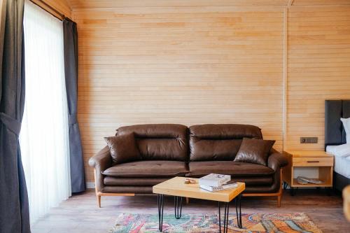 契拉勒Serenity Bungalows的客厅配有棕色沙发和桌子