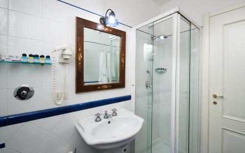 那不勒斯齐亚贾魅力酒店的一间带水槽和玻璃淋浴的浴室