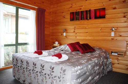 汉默温泉小木屋汽车旅馆的一间卧室配有一张床,上面有两条毛巾
