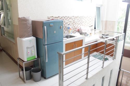 万隆G10 Guest House Near Asia Afrika Bandung的厨房配有蓝色冰箱和水槽