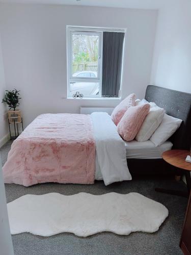 曼彻斯特Shared Modern Apartment Double Bedroom With Attached Bath的一间卧室配有一张带粉色和白色床单的床和窗户。