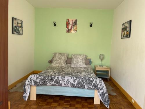 德朗西CALME的卧室配有一张床,墙上挂有两张照片