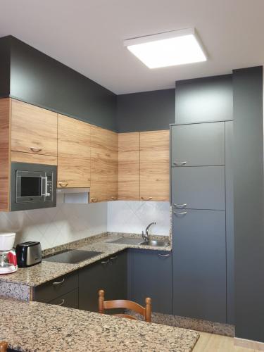 蒙塔尔沃大西洋度假公寓式酒店的厨房配有木制橱柜和不锈钢冰箱。