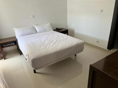 努瓦迪布HOTEL NAKHIL的一张带白色床单和枕头的床