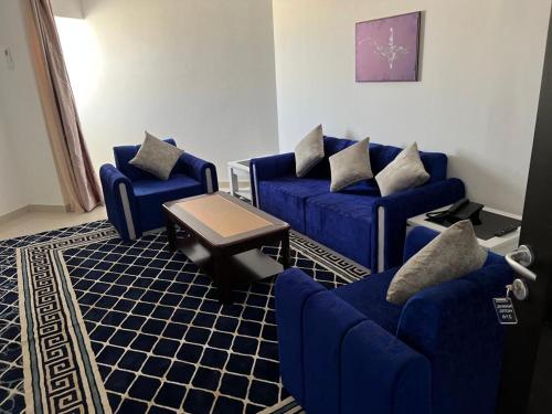 努瓦迪布HOTEL NAKHIL的客厅配有蓝色的沙发和桌子