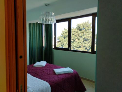 卡普多兰多franci e aurora house的一间卧室设有紫色的床和窗户
