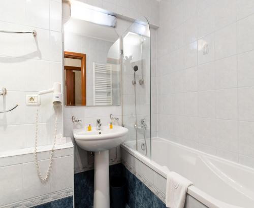 蒂米什瓦拉Hotel Excelsior的白色的浴室设有水槽和淋浴。