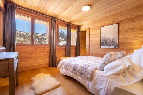 瓦尔Chalet Mountainside avec sauna et jacuzzi à 200m des pistes的卧室配有一张床、一张书桌和窗户。