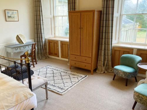 莫珀斯Meldon Cottage in Morpeth, Northumberland的一间卧室配有一张床、一个梳妆台和两个窗户。