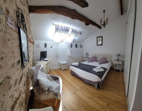 SolignacLes hauts Brianço的一间卧室,卧室内配有一张床和一把椅子