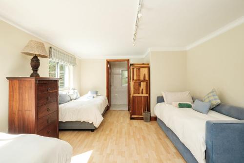 自然谷10 St Andrews Avenue的一间卧室配有两张床和蓝色的沙发