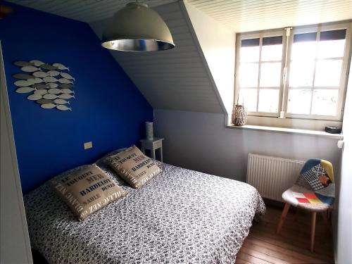 圣康坦昂图尔蒙Les Sableaux, les portes du Marquenterre的一间卧室设有蓝色的墙壁和一张带枕头的床。