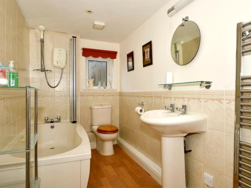 格伦里丁Mollys Cottage的一间带水槽、卫生间和镜子的浴室