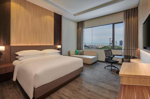 马六甲Courtyard by Marriott Melaka的配有一张床和一张书桌的酒店客房