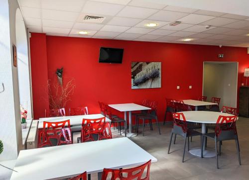 佩罗讷Auberge des Remparts的用餐室设有红色的墙壁、桌子和红色的椅子