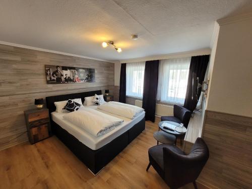 巴特布拉姆施泰特Hotel MoinMoin的一间卧室配有一张大床和一把椅子