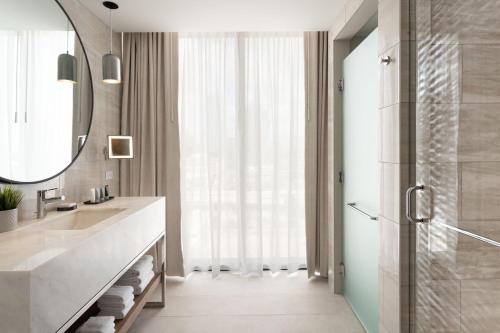 坦帕JW Marriott Tampa Water Street的一间带水槽、镜子和淋浴的浴室