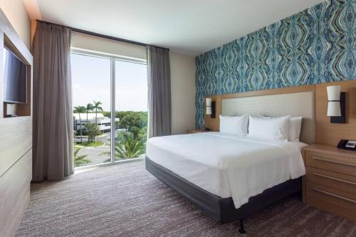 棕榈滩花园Residence Inn Palm Beach Gardens的酒店客房设有一张床和一个大窗户