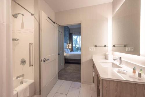 棕榈滩花园Residence Inn Palm Beach Gardens的浴室配有2个盥洗盆、淋浴和浴缸。