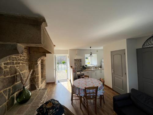 塔登La maison d'André的客厅配有桌子和石头壁炉