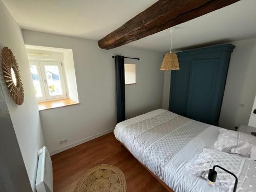 塔登La maison d'André的一间卧室配有一张带蓝色床头板的床和窗户