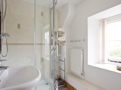 Cold Ashton罗斯度假屋的白色的浴室设有水槽和淋浴。