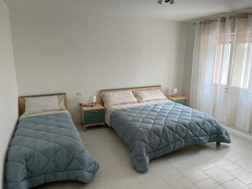 圣温琴佐Giardino Sud - a pochi passi dal mare的一间卧室设有两张床和窗户。