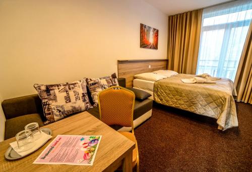 鲁容贝罗克哈勃沃酒店的酒店客房配有一张床铺和一张桌子。
