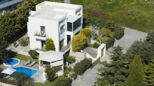 罗希姆诺Kastellakia Executive Villa的享有白色房屋空中美景,设有游泳池