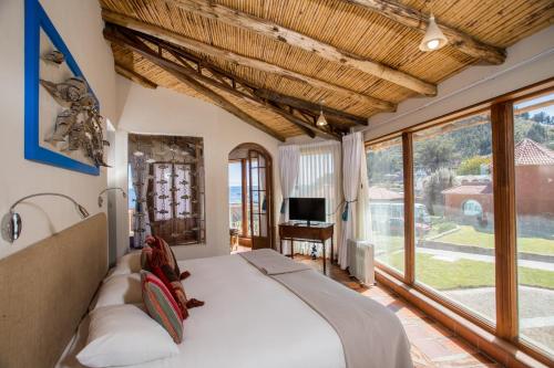 科帕卡巴纳罗萨里奥拉戈提提卡卡酒店的一间卧室设有一张床和一个大窗户
