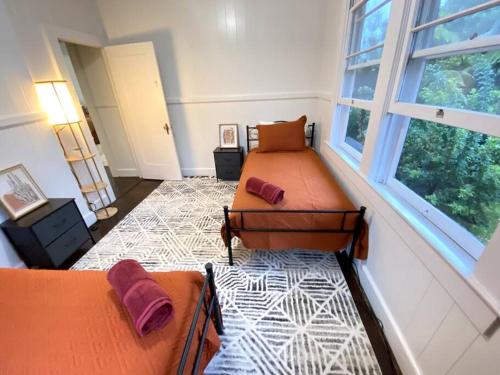 希洛YOUR HILO HOMEBASE - Lovely 3 Bedroom in Heart of Hilo with AC!的一间卧室设有两张床和窗户。
