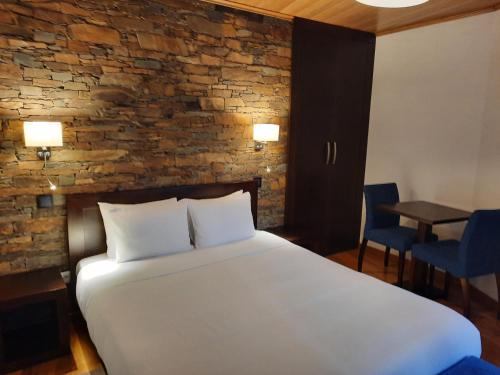 Chão SobralCasa da Eira de Cima的一间卧室设有一张大床和砖墙
