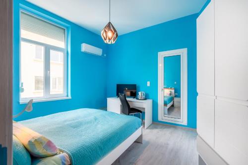 布尔加斯ПАЦО的蓝色的卧室配有床、书桌和镜子