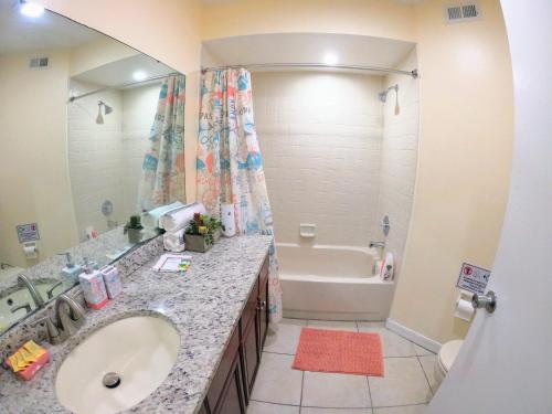 奥兰多Orlando Vacation Apartment 3919的一间带水槽、浴缸和镜子的浴室