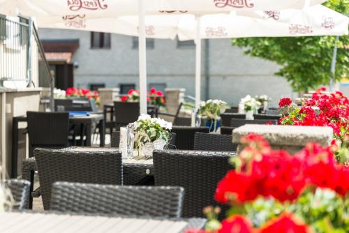 涅德托辛根克罗恩酒店的户外庭院配有桌椅和红色鲜花